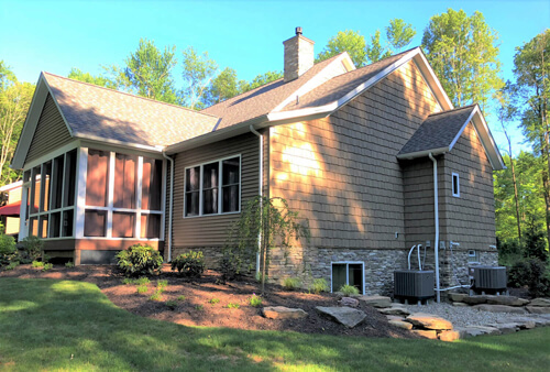 Backyard view of house and sunroom