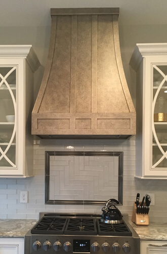 View of the backsplash and hood over the stove in the kitchen
